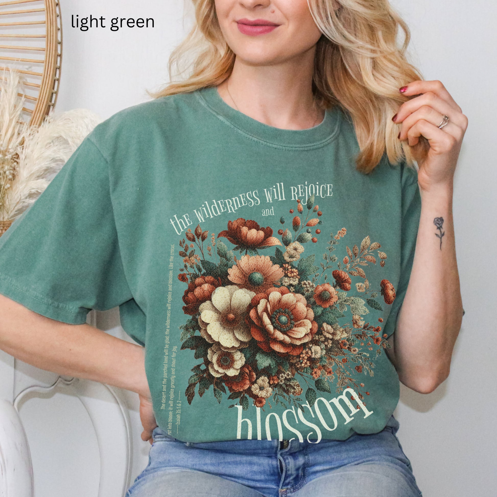 Christian t-shirt with boho design and Bible verse saying the wilderness will blossom in Comfort Colors light green color